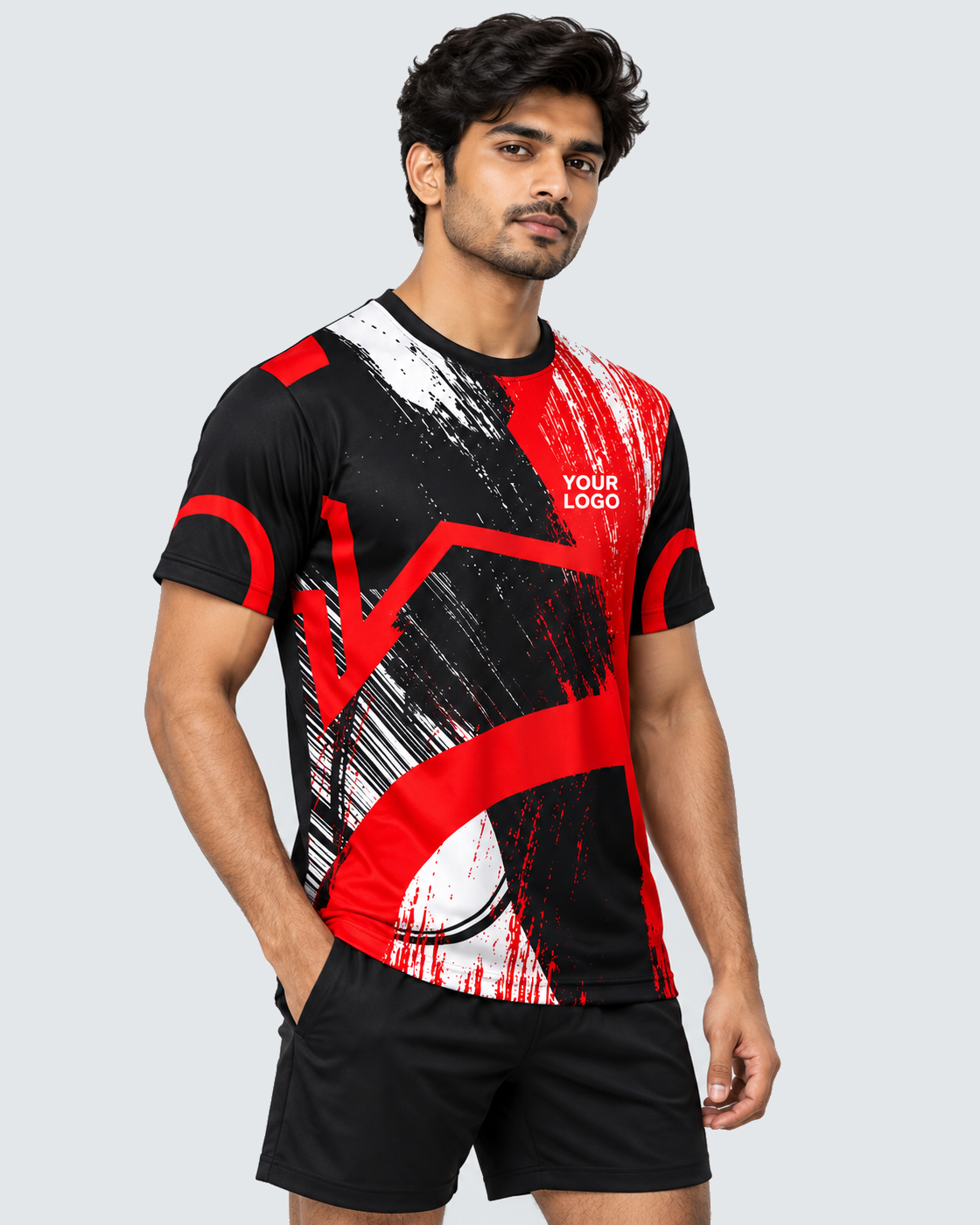 Angled view of crimson brushstroke custom sports jersey on an Indian male model with plain black shorts