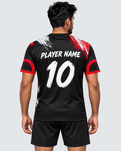 Back view of crimson brushstroke custom sports jersey showing PLAYER NAME 10 on an Indian male model with plain black shorts