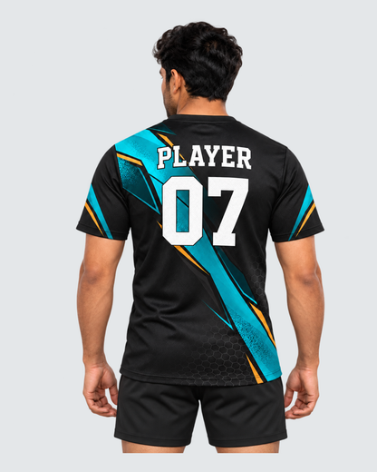 Carbon Tide, Back view with PLAYER and 07 placeholders; Indian male model, black sports shorts, solid #E4E7E9 background, portrait 4:5