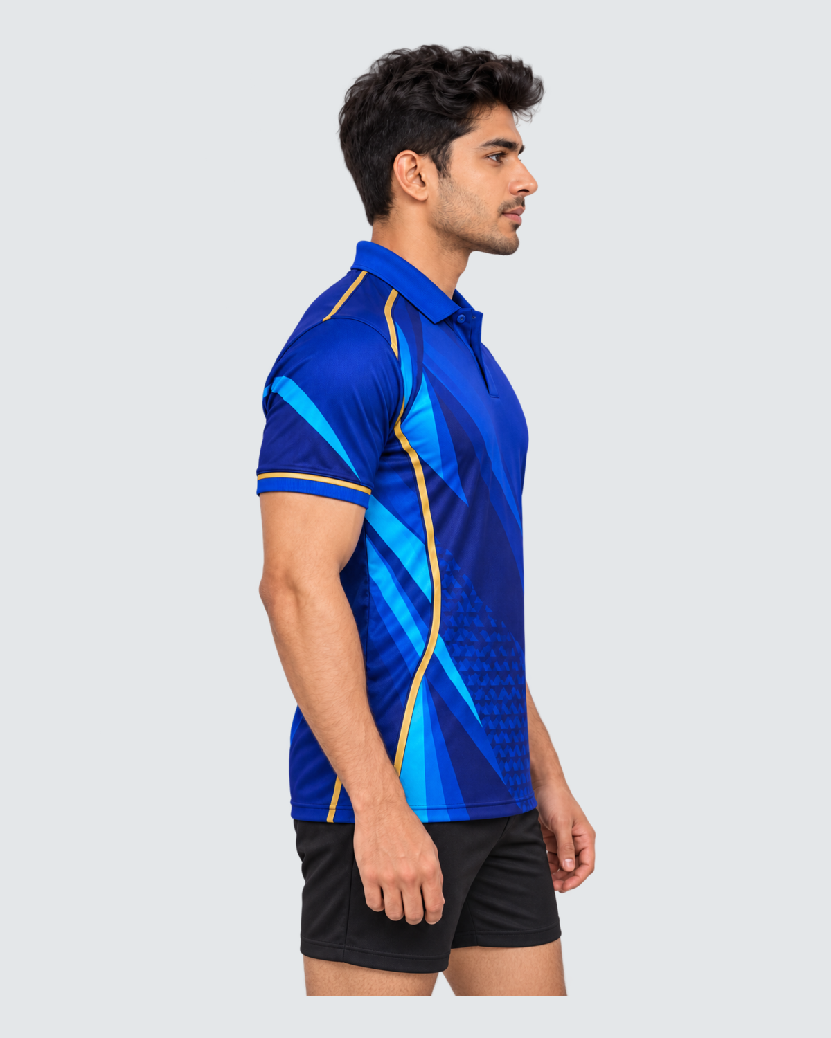 Cobalt Motion, Left profile; Indian male model, black sports shorts, solid #E4E7E9 background, portrait 4:5