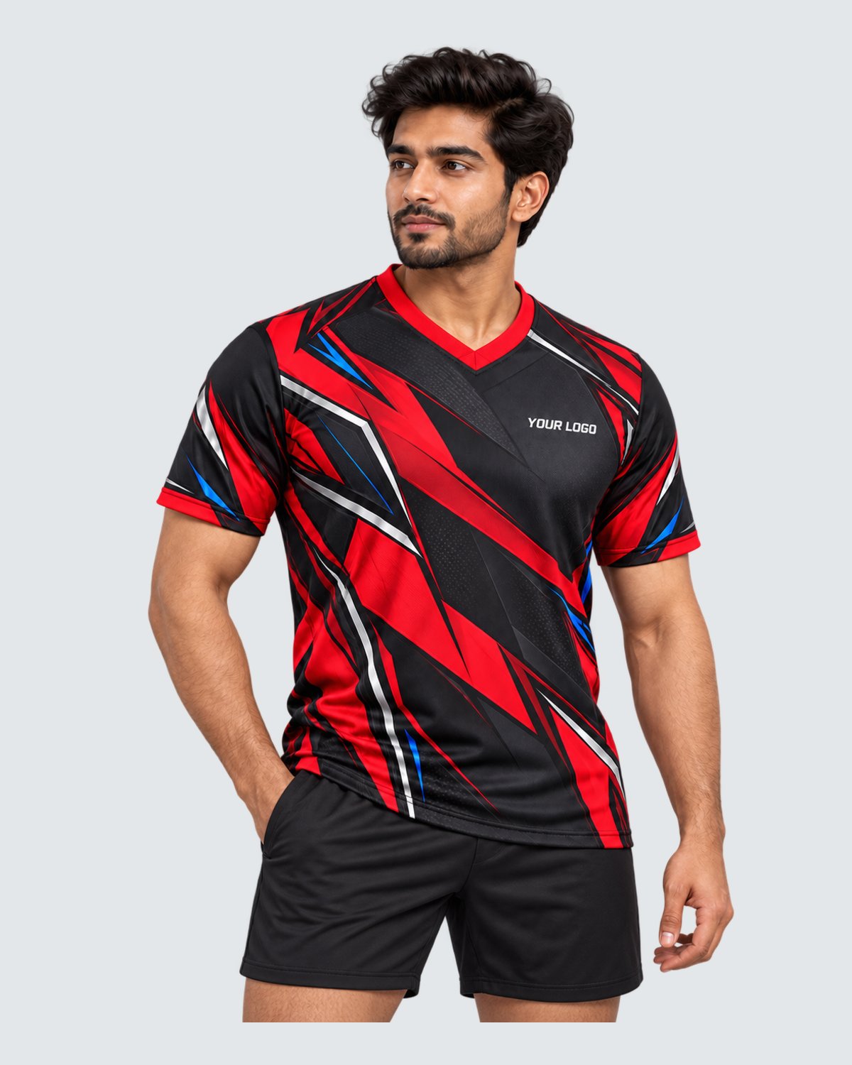 Crimson Flux, Three-quarter front view; Indian male model, black sports shorts, solid #E4E7E9 background, portrait 4:5