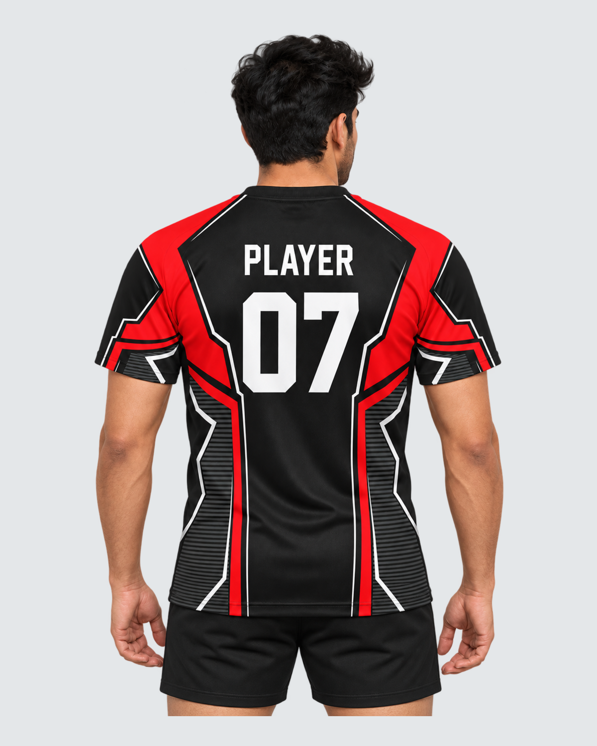Crimson Frame, Back view with PLAYER and 07 placeholders; Indian male model, black sports shorts, solid #E4E7E9 background, portrait 4:5