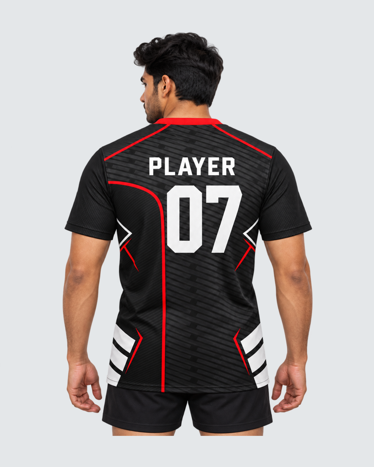 Redline Shadow, Back view with PLAYER and 07 placeholders; Indian male model, black sports shorts, solid #E4E7E9 background, portrait 4:5