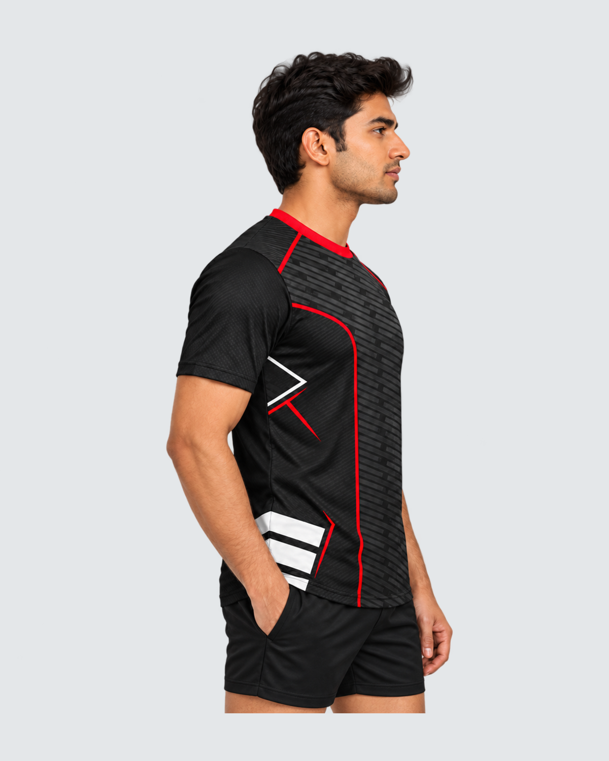 Redline Shadow, Left profile; Indian male model, black sports shorts, solid #E4E7E9 background, portrait 4:5